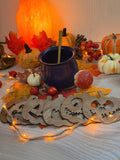 Lot de 7 dessous de verre "Esprits d'Automne" en bois découpé au laser, visages de citrouilles Halloween, disposés autour d'un chaudron et de citrouilles - L'Atelier du Moulin