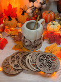 Dessous de verre ajourés "Feuillage d'Automne" en bois de peuplier découpé au laser, motifs de feuilles, disposés près d'une tasse et de citrouilles - L'Atelier du Moulin