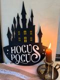 Plaque château de sorcières "Hocus Pocus" en bois noir découpé au laser, fenêtres peintes en jaune lumineux, décoration Halloween - L'Atelier du Moulin