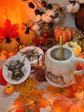 Sous-verres en MDF effet marbre gravés au laser d'une tête de vache Highland, présentés dans un décor d'automne avec citrouilles et feuilles - L'Atelier du Moulin