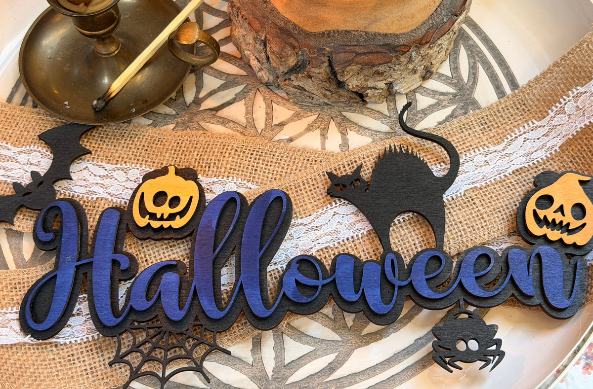 Plaque décorative "Halloween" en bois peint violet et bleu nuit, avec citrouilles, chat noir, chauve-souris, araignée et toile - L'Atelier du Moulin